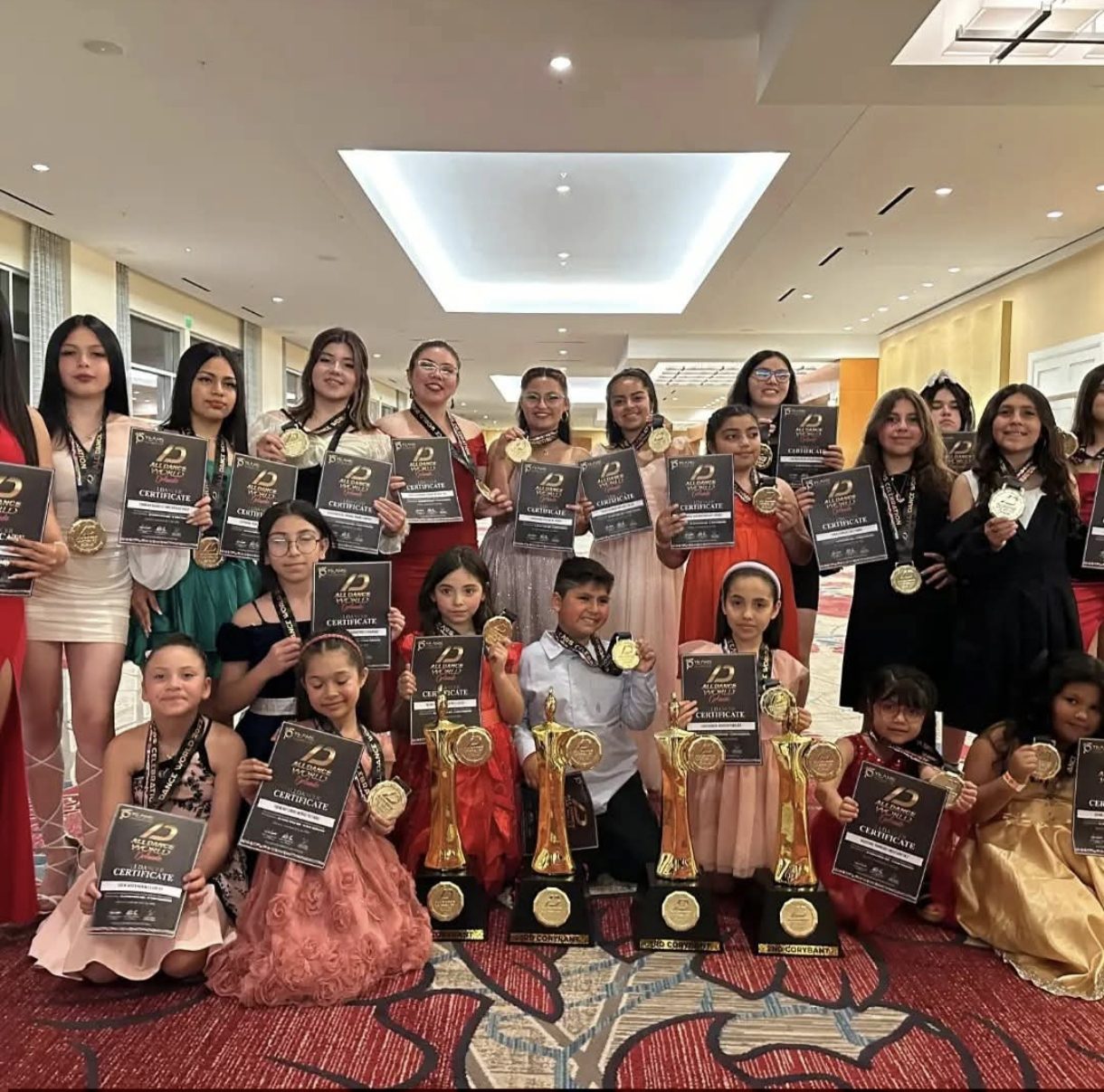 Alumnas y alumnos de Dance Studio 5 con sus medallas y trofeos tras una competencia