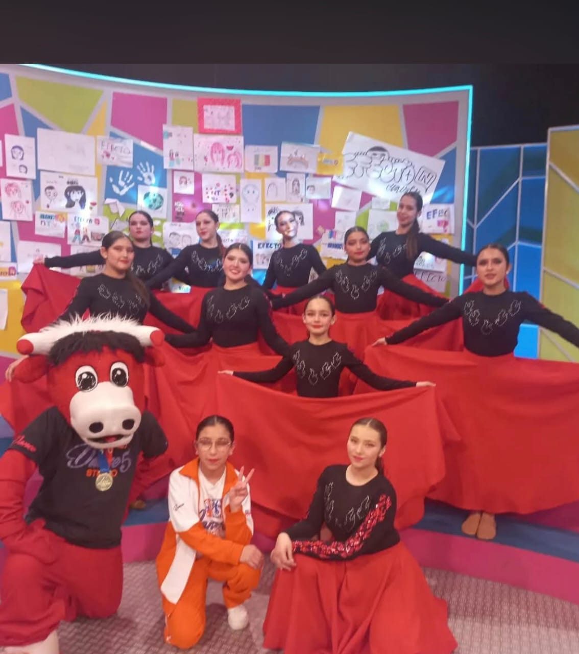 Dance Studio 5 en el set de televisión, con vestuario rojo y la mascota del programa