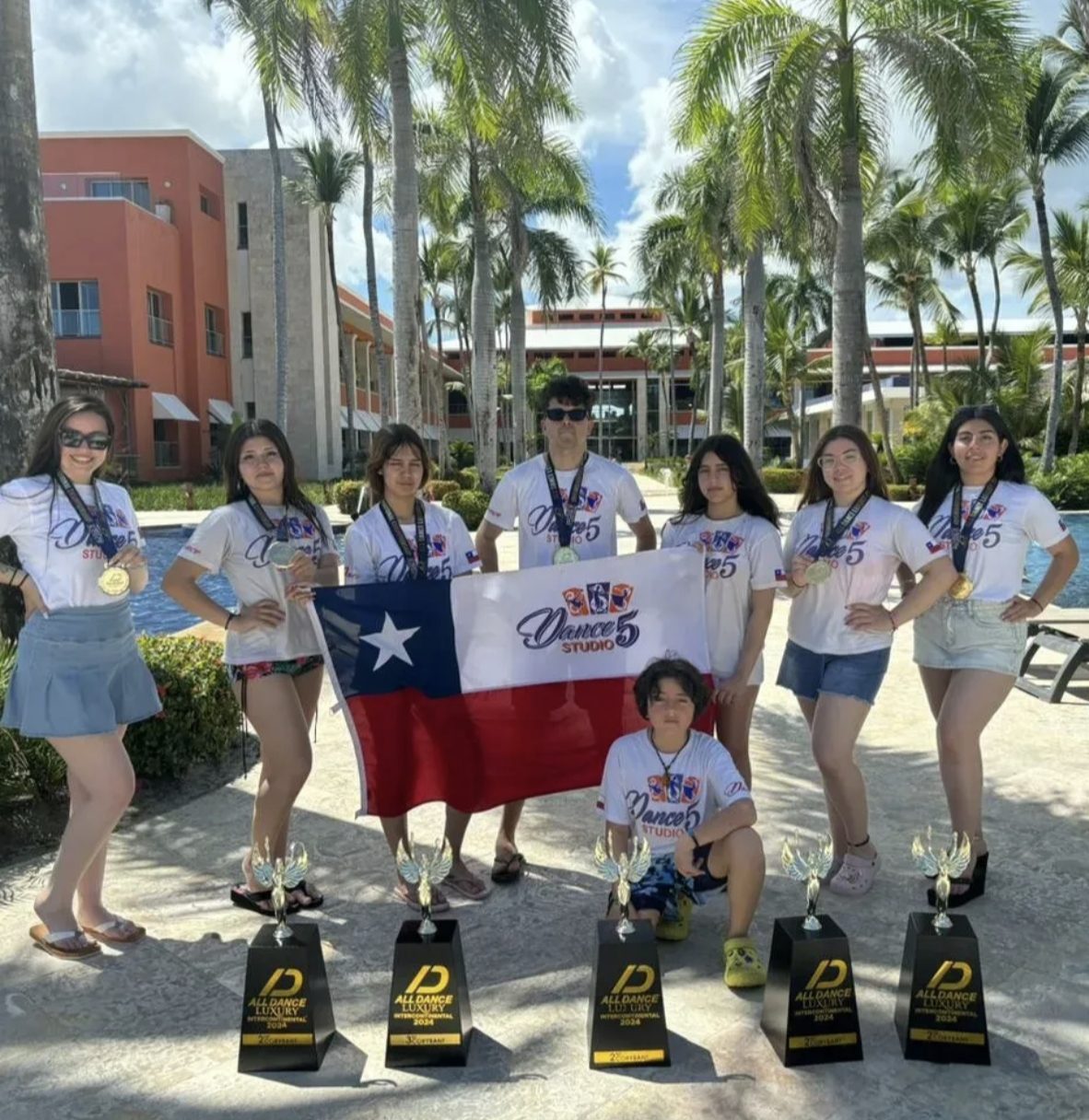 Delegación de Dance Studio 5 con la bandera chilena y sus trofeos en una gira internacional