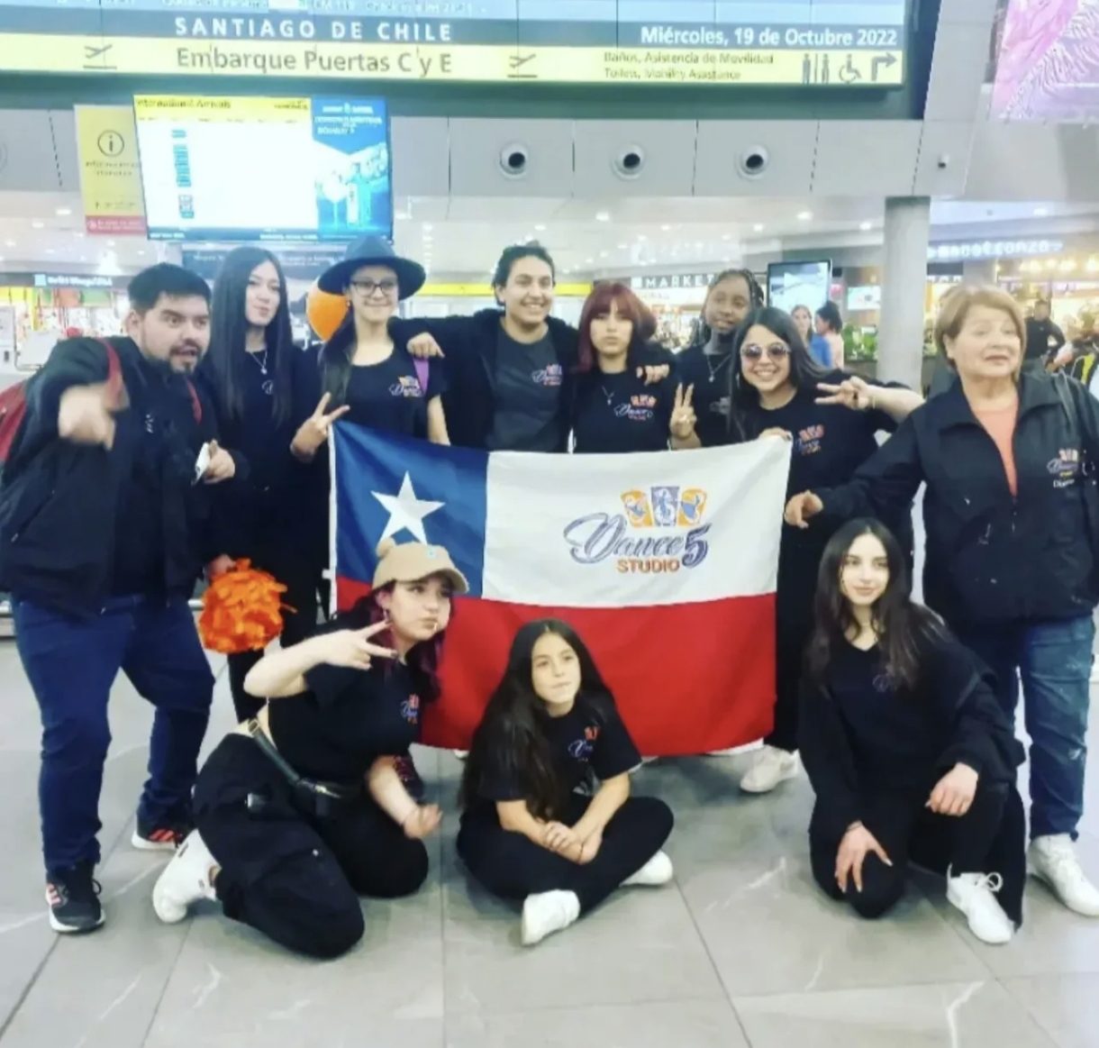 Delegación de Dance Studio 5 con la bandera chilena en el aeropuerto de Santiago antes de viajar