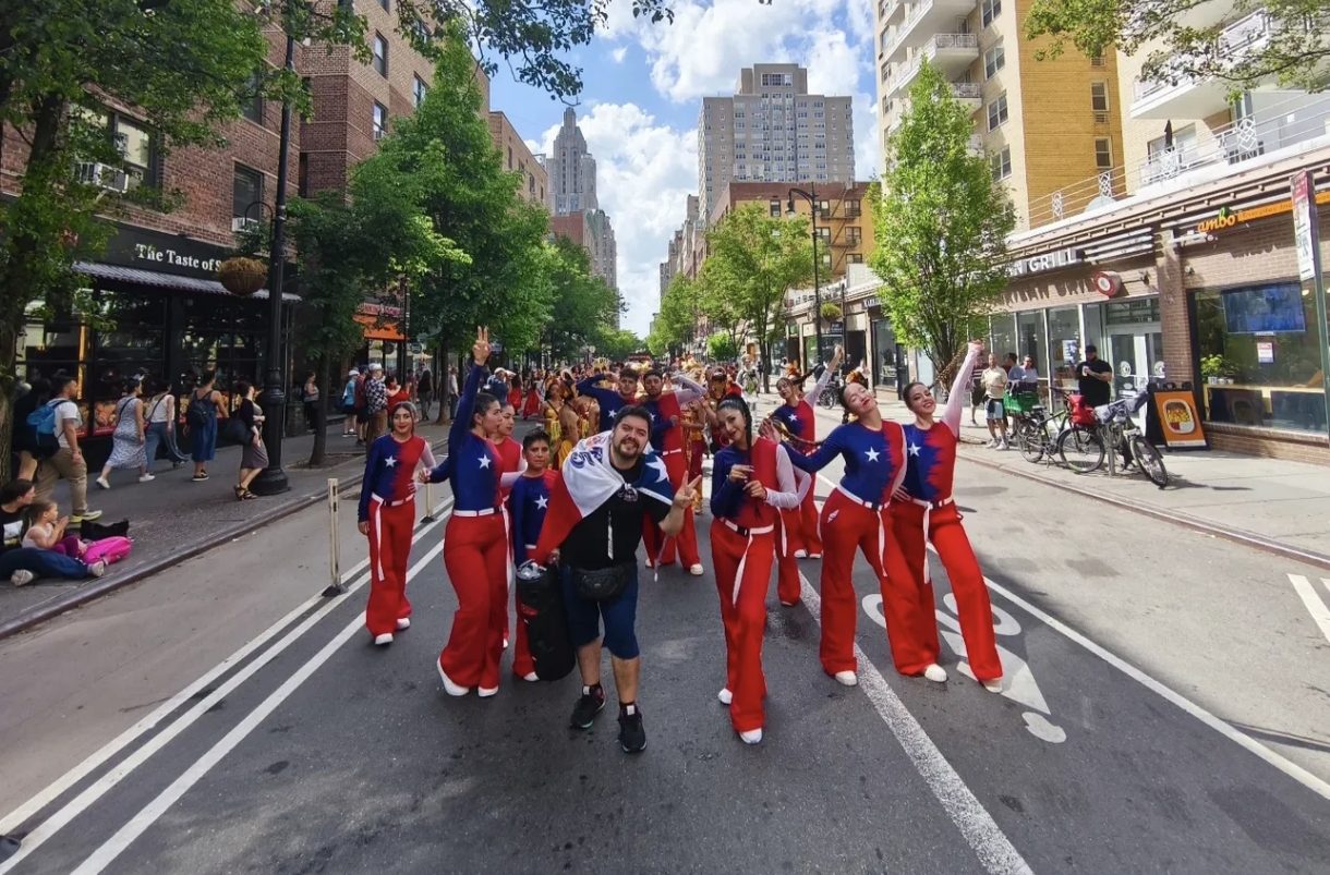 Grupo de Dance Studio 5 desfilando por la calle con vestuario rojo y azul