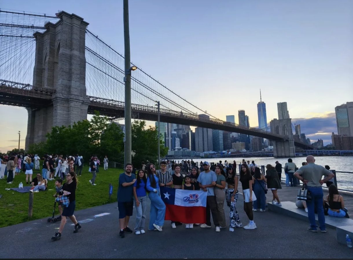 Delegación de Dance Studio 5 con la bandera chilena frente al puente de Brooklyn, Nueva York